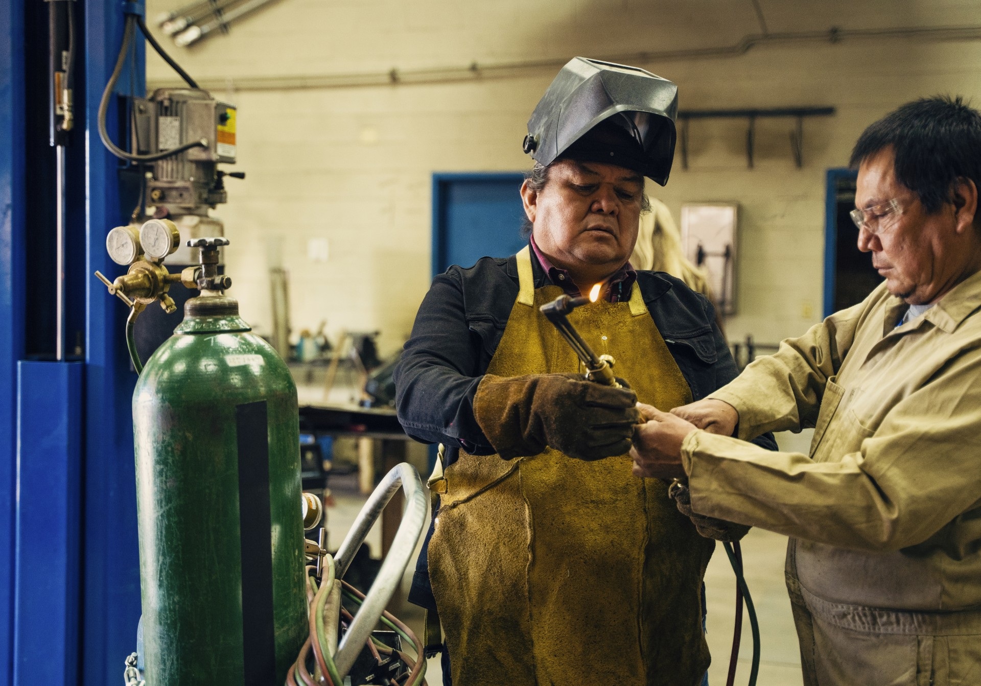 Middle-aged man learning to weld with his instructor.