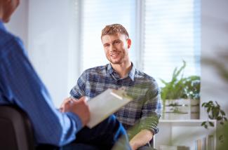 Smiling student in conversation with a male caseworker.