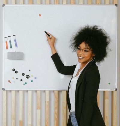 Smiling African American woman about to write on whiteboard.