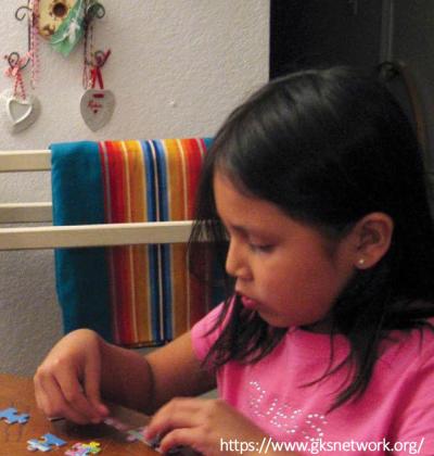 Native grandmother doing a puzzle with Native child.