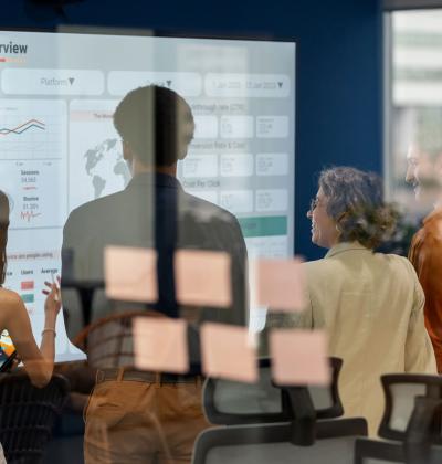 Team brainstorming in front of digital analytics display.