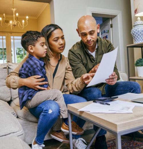 Young Hispanic couple and son reviewing financial documents.