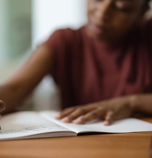Young Black woman immersed in writing.