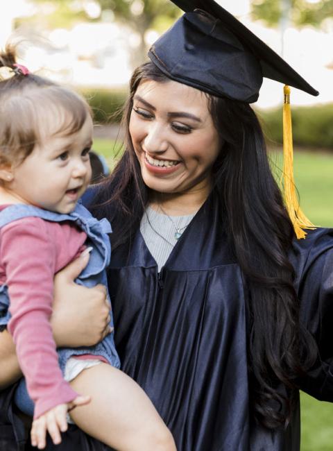 The young mother celebrates completing her education while holding her daughter.